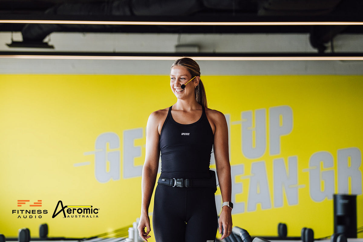 Yoga instructors teaching a heated class with Fitness Audio headset microphones