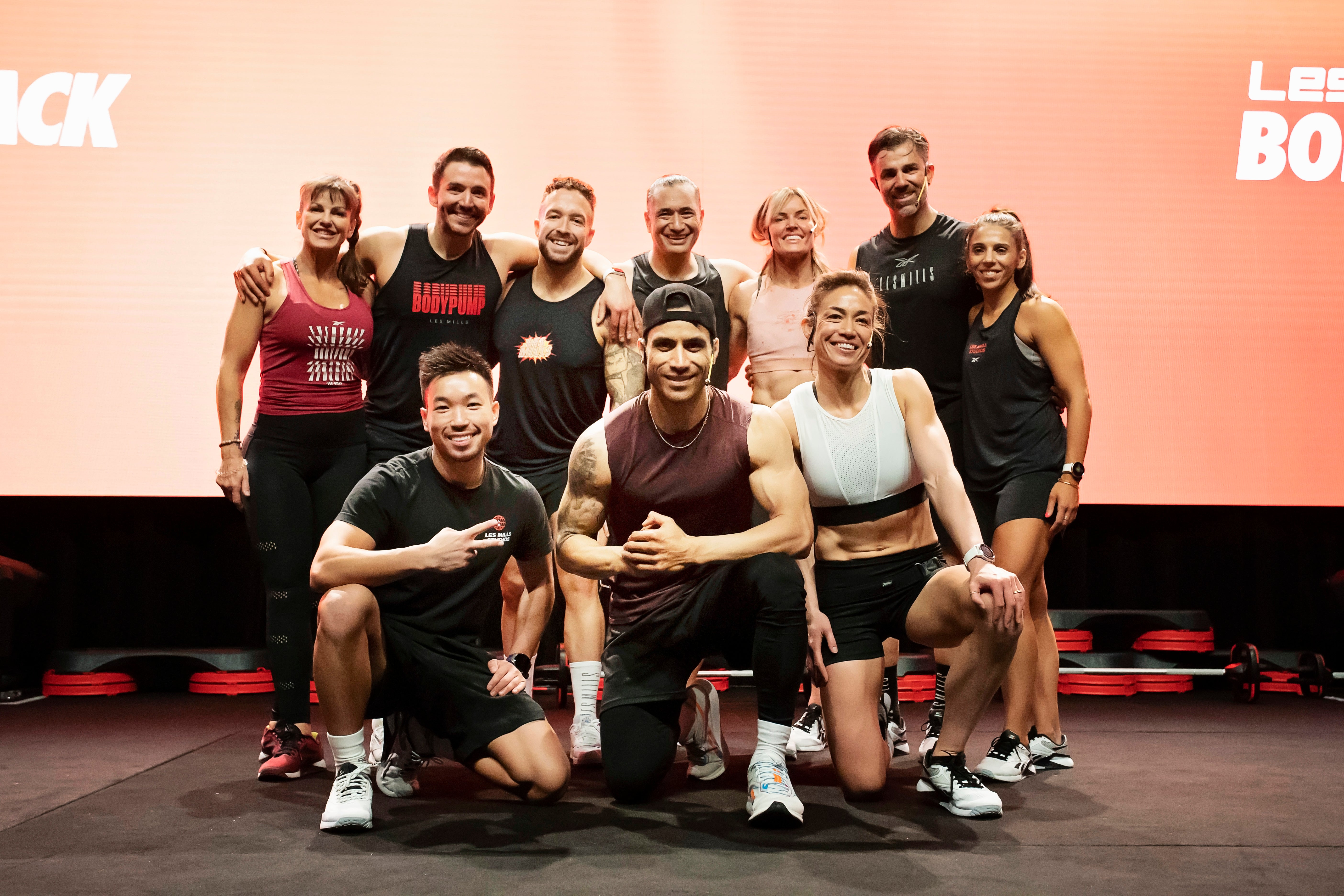 Group of people posing together on a stage smiling.