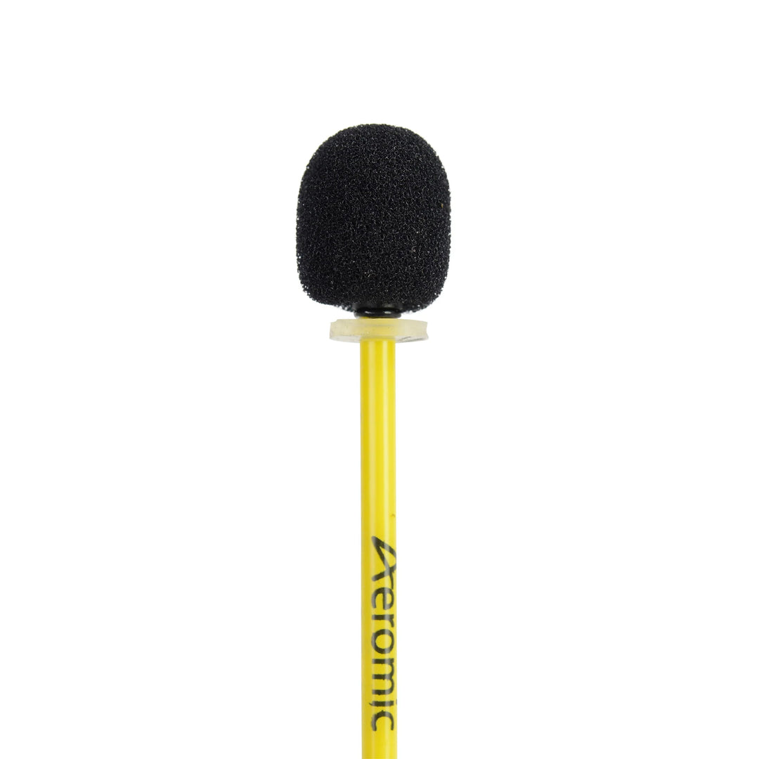 A black oval foam windscreen covering a microphone on the end of the boom arm of a yellow Aeromic headset.