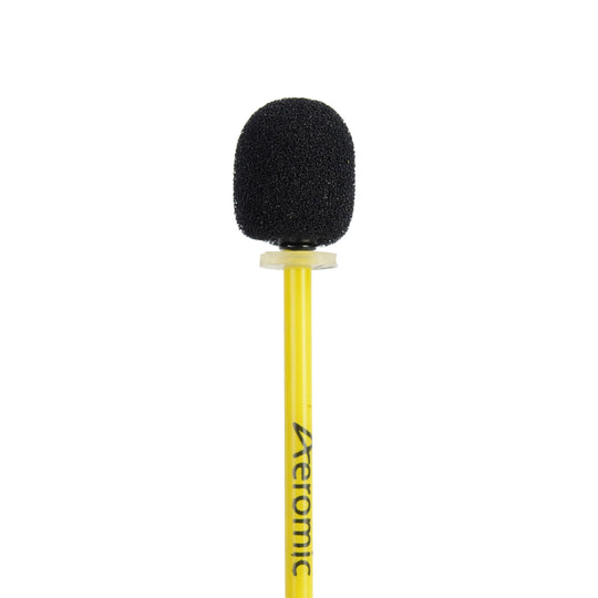 A black oval foam windscreen covering a microphone on the end of the boom arm of a yellow Aeromic headset.